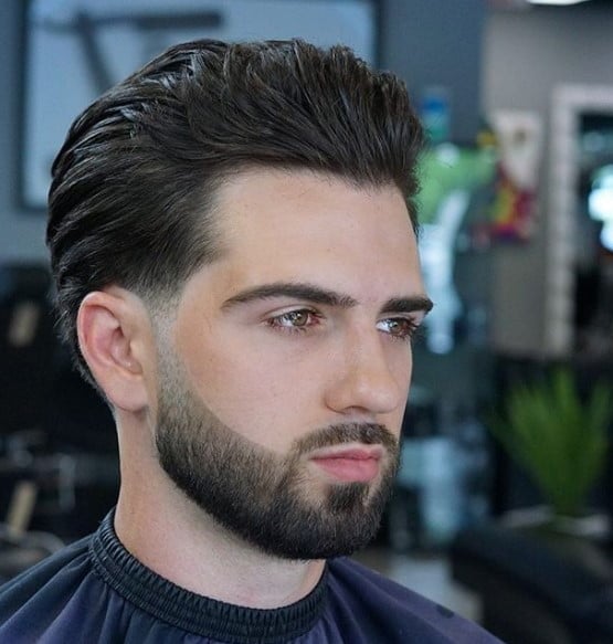 a man with a layered hairstyle with a cleanly trimmed facial hair