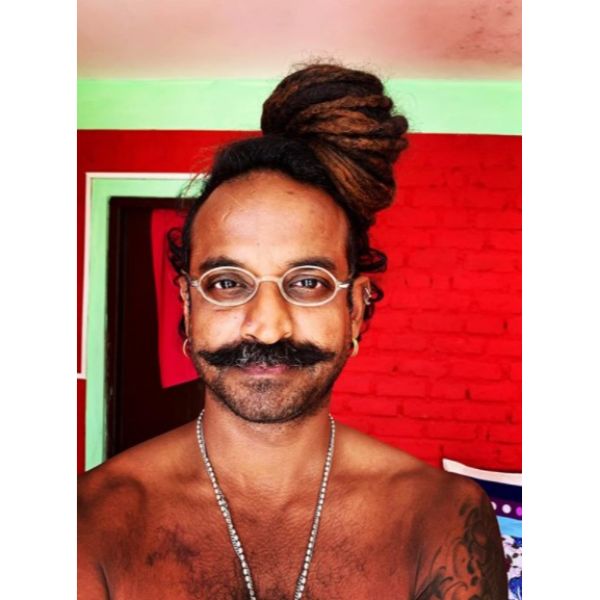 a man with Side Dreadlock with styled mustache wearing eyeglasses
