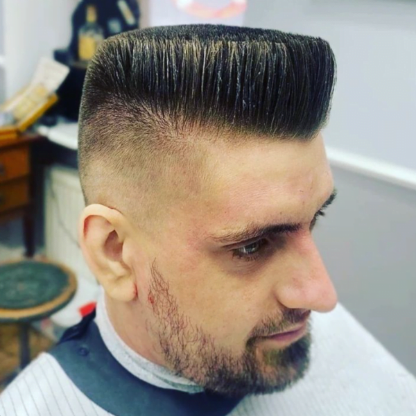 Man wearing barber's cape with beard in his Medium Solid Flat Top Haircut