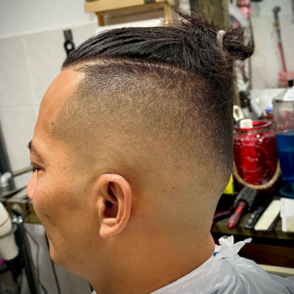 Man had his hair styled into Temp Fade with Top Knot