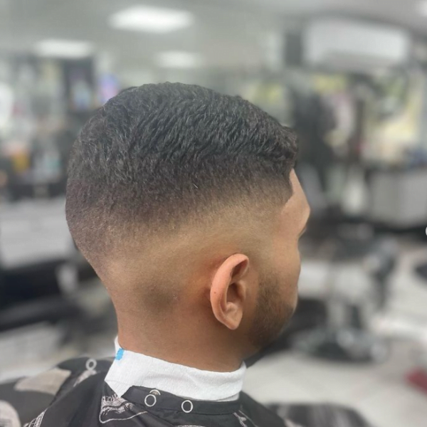 Man wearing barber's cape - Temple Low Fade for Men